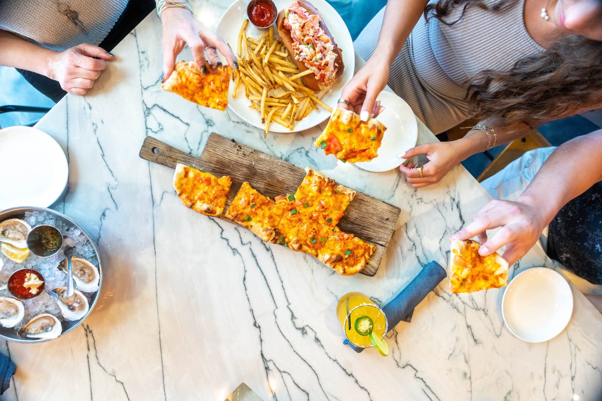 Top down view of a restaurant table with pizza and drinks.